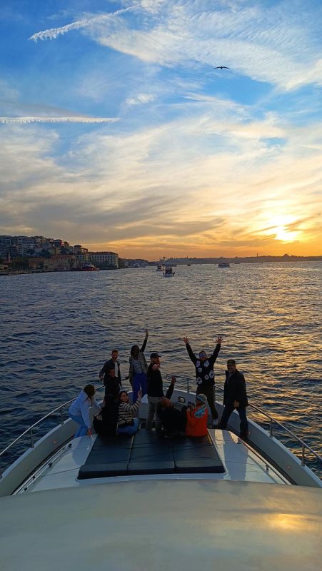 Guests celebrating on a private yacht deck at sunset on the Bosphorus