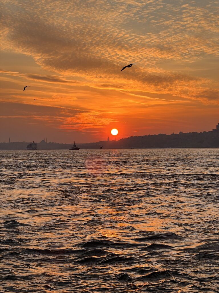 Orangefarbener Sonnenuntergangshimmel über dem Bosporus, von einer privaten Yacht aus