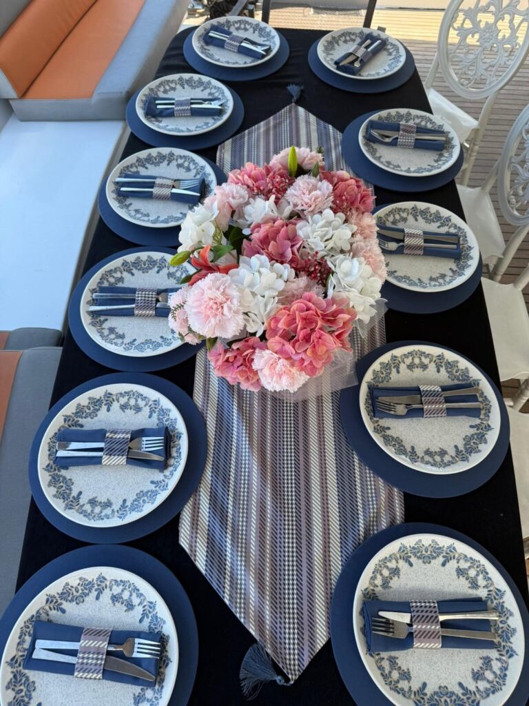 Elegant table setting with a fresh flower runner on a yacht
