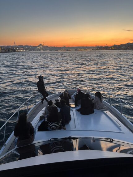 Friends enjoying golden hour on the foredeck of a private Bosphorus yacht