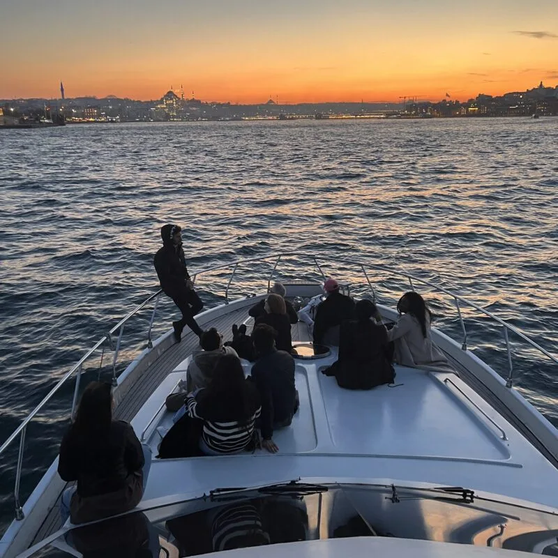 Friends enjoying golden hour on the foredeck of a private Bosphorus yacht
