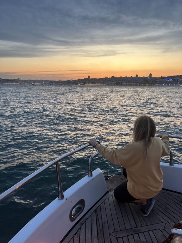 Guest enjoying golden hour on the bow of a private yacht in Istanbul