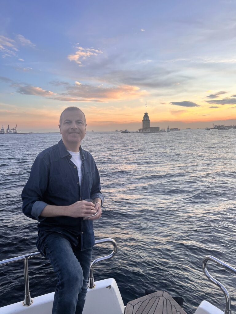 Guest portrait at sunset with the Maiden's Tower behind, on a Bosphorus yacht