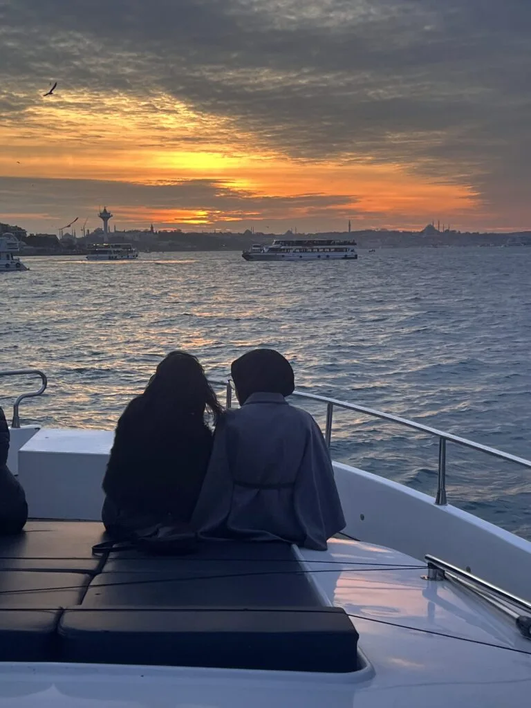 Gäste beobachten den Sonnenuntergang vom Vordeck der Yacht am Bosporus