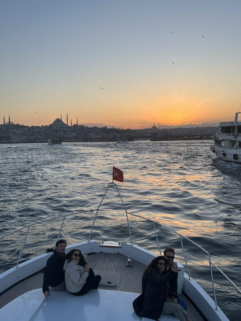 Paar entspannt am Bug der Yacht, dahinter die Skyline der historischen Halbinsel