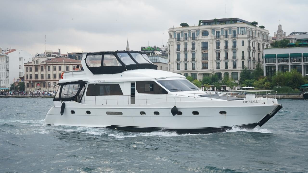 Motor yacht cruising past waterfront buildings on the Bosphorus
