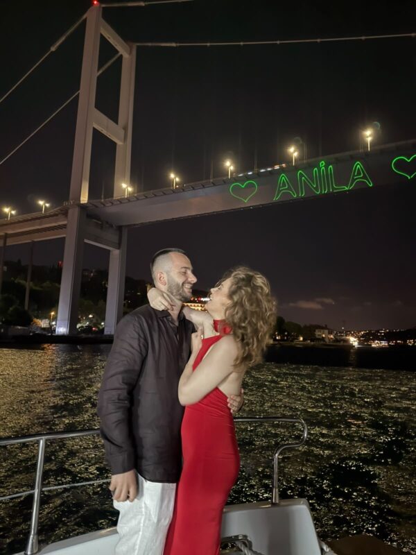 Marriage proposal on a yacht with a light message on the Bosphorus Bridge