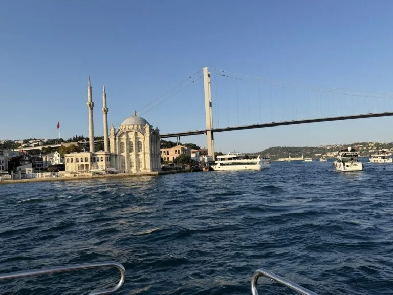 Ortaköy Mosque with the 15 July Martyrs Bridge rising directly behind it, seen from the water on a Bosphorus cruise