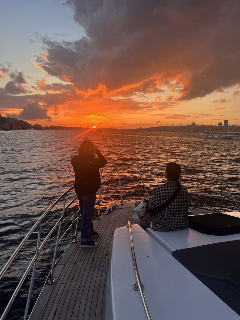Silhouette eines Paares am Bug der Yacht unter rotem Sonnenuntergangshimmel auf dem Bosporus
