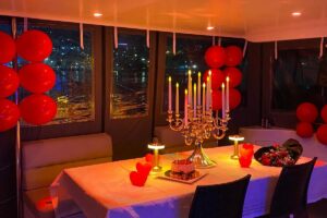 Romantic table setup with red balloons and candelabra in the yacht salon
