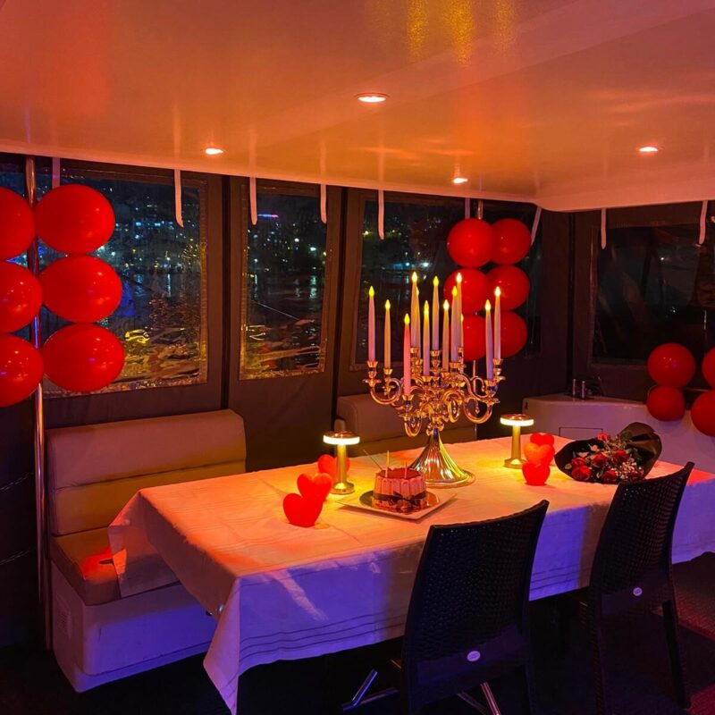 Romantic table setup with red balloons and candelabra in the yacht salon