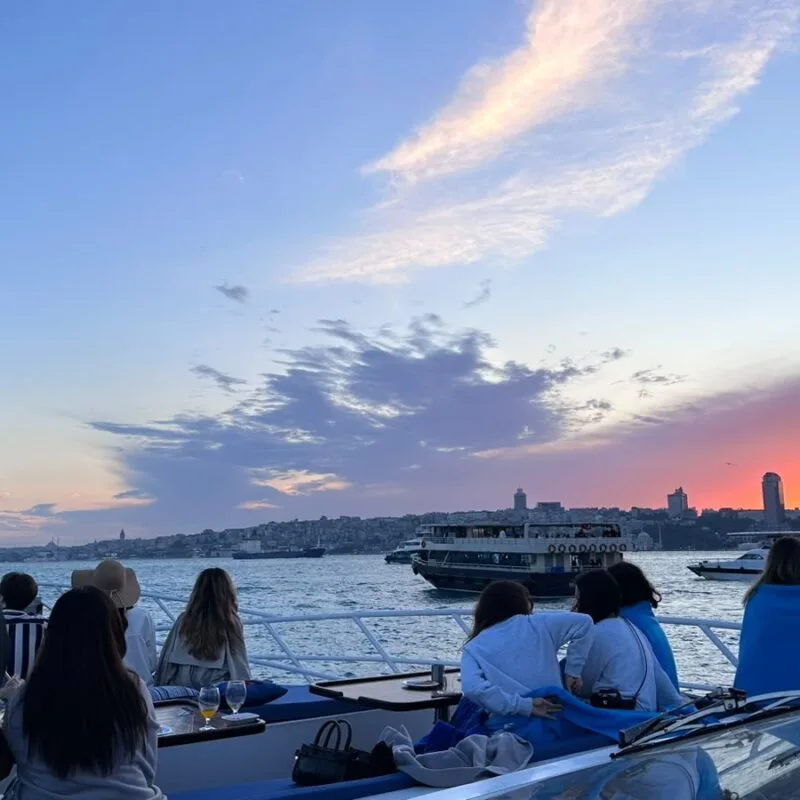 Guests watching the sunset from the deck on a shared Bosphorus group cruise in Istanbul