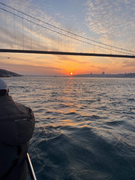 Sun setting under the Bosphorus Bridge, viewed from a yacht deck