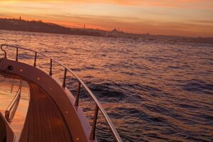 Teak deck curve of a luxury yacht under the sunset light