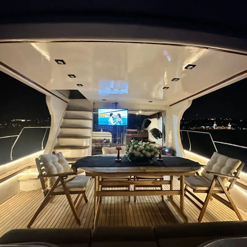 Tuana yacht saloon at night with table set for guests