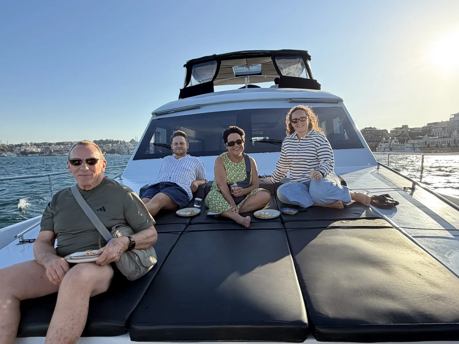 Guests aboard a private daytime yacht charter in Istanbul cruising the Bosphorus past Dolmabahçe Palace